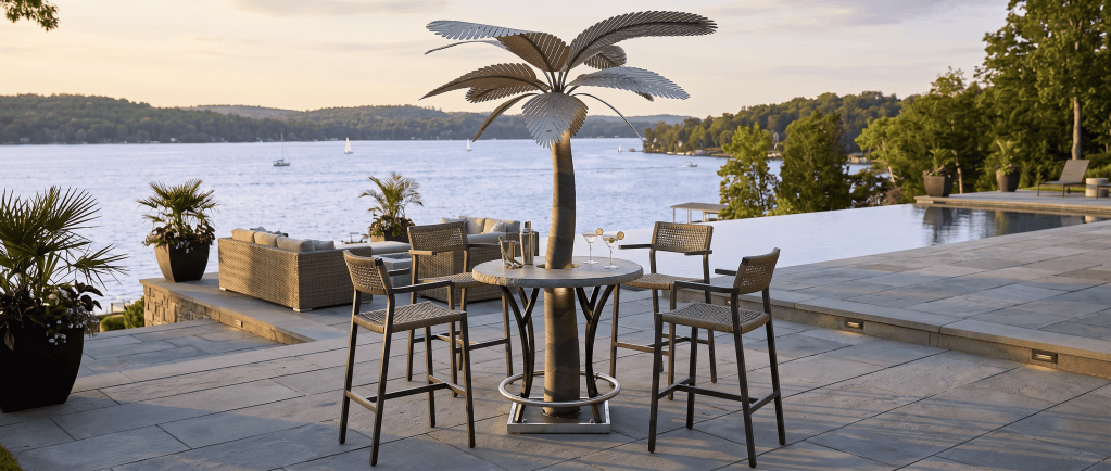 Outdoor patio with designer palm trees and seating overlooking a lake.
